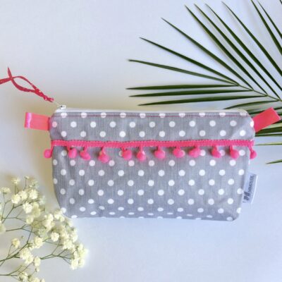 Trousse enduite grise à pois blancs, pompons rose fluo, doublure hawaïenne